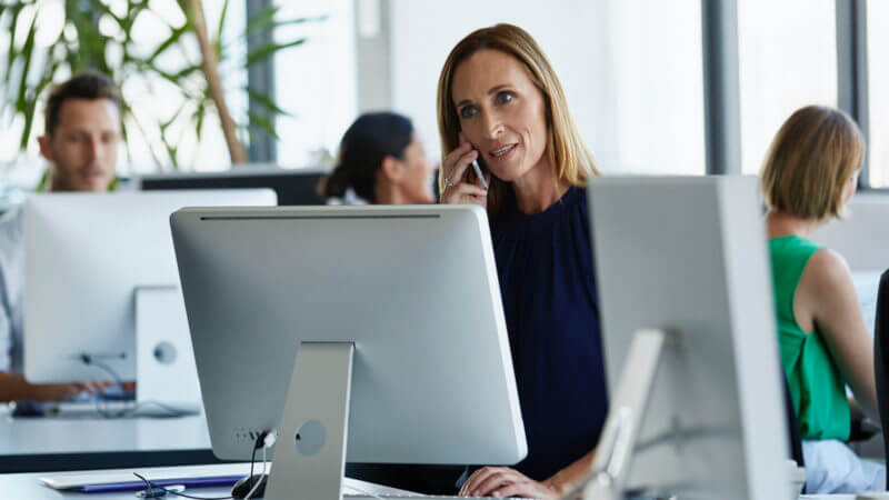 A woman on the phone for hotline compliance services